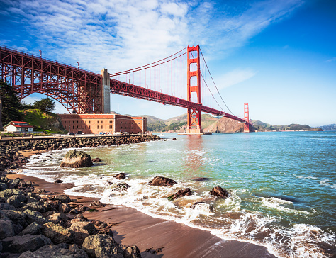 A daytime view of San Francisco's iconic Golden Gate Bridge, photographed from the beach.