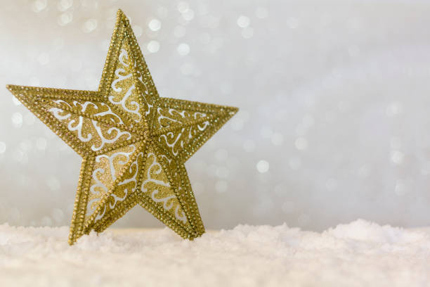 istock Golden christmas star on snow with sparkle bokeh background with copy space 1284263479