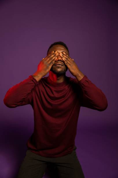 istock Black Man Covering Eyes with Hands 1284265287