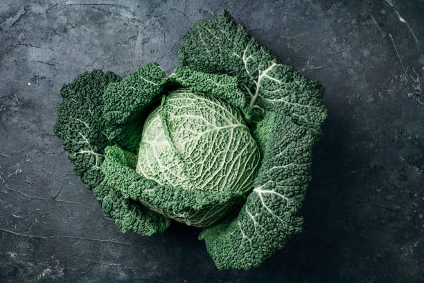 istock Raw green cabbage texture. Organic savoy cabbage on dark background. Top view. Copy space. Vegan and vegetarian diet concept 1284268754