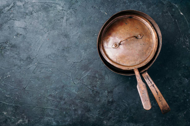 istock Old vintage copper pots on dark background. Kitchen utensils. Rustic pan. Top view, copy space for your text 1284268774