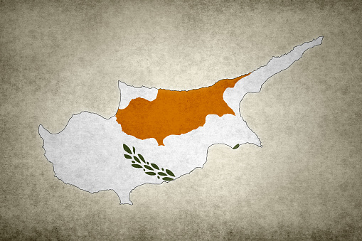 Grunge map of Cyprus with its flag printed within its border on an old paper.