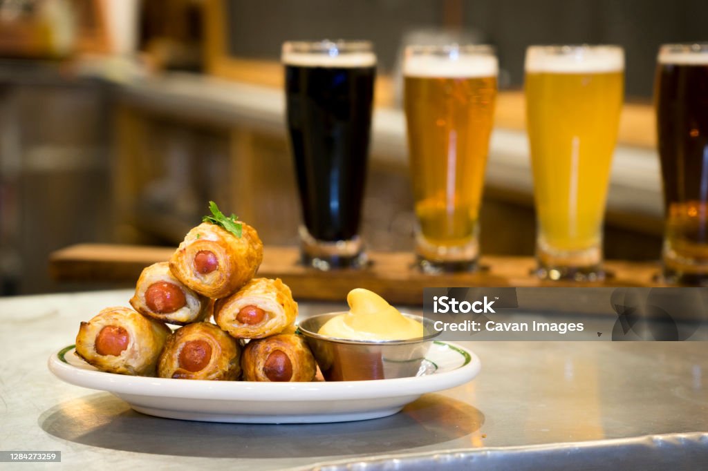 A plate of pigs in a blanket and a beer flight A plate of pigs in a blanket and a beer flight in United States, New York, New York Pigs in a Blanket Stock Photo