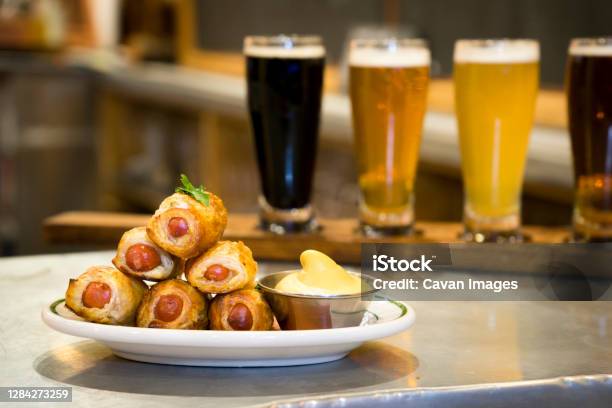 A Plate Of Pigs In A Blanket And A Beer Flight Stock Photo - Download Image Now - Pigs in a Blanket, Food, Beer - Alcohol