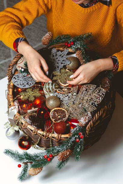 istock Young Woman with a Box Choosing Christmas Decorations in a Baske 1284275432
