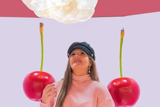 istock young woman in hat looking up posing with giant cherries 1284277292