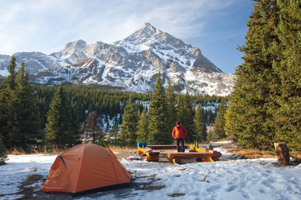 Winter Camping In Mountains With Caucasian Man Standing By Fire