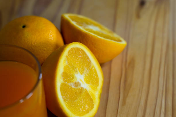 verre de jus d’orange sur la table en bois - isolated on white orange juice ripe leaf photos et images de collection