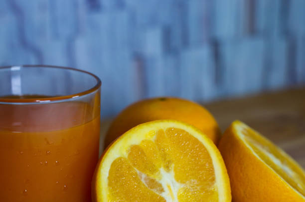 verre de jus d’orange sur la table en bois - isolated on white orange juice ripe leaf photos et images de collection