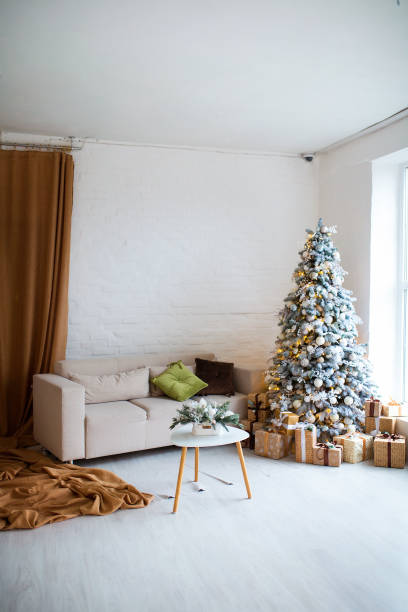istock Interior of bright modern living room with comfortable sofa decorated with Christmas tree and gifts 1284279810