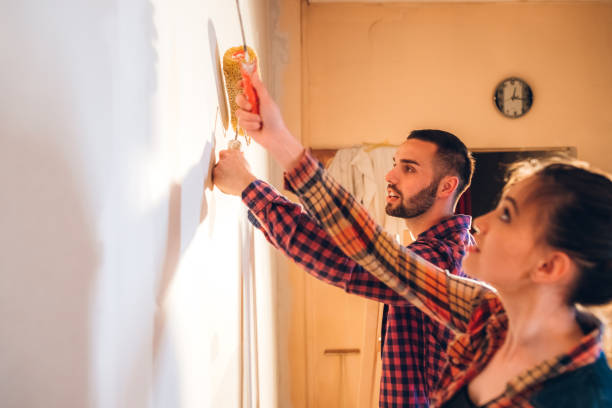 istock Young couple painting wall 1284279824