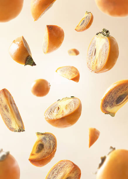 istock Collection of falling persimmon on beige pastel background. 1284279829