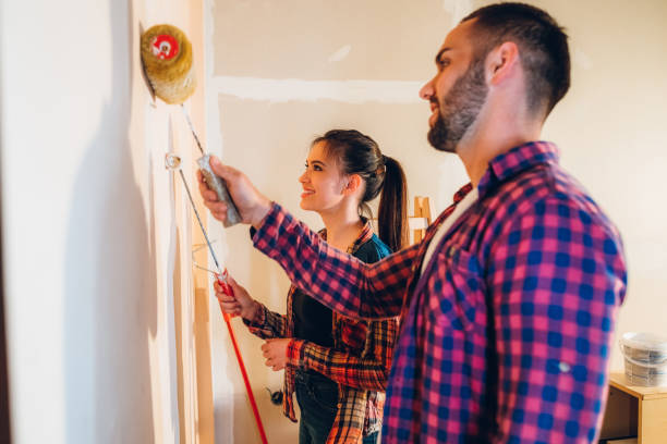 istock Young couple painting wall 1284279861