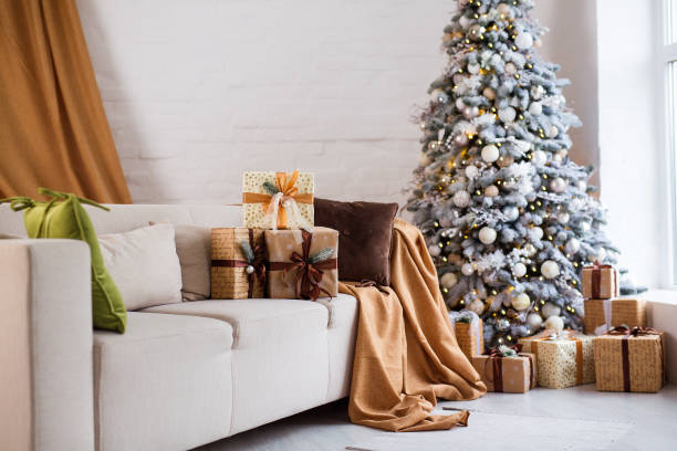 istock Interior of bright modern living room with comfortable sofa decorated with Christmas tree and gifts 1284280529