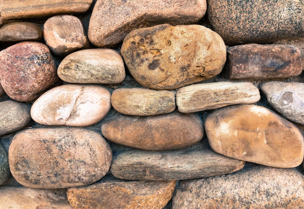 istock River Rock Wall with Pinkish-Gray Stone 1284281772