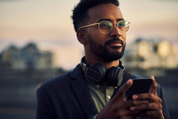 He's on a mission Cropped shot of a handsome young businessman using his cellphone while out in the city beard photos stock pictures, royalty-free photos & images