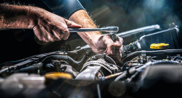 Auto mechanic working on car engine in mechanics garage. Repair service. authentic close-up shot Auto mechanic working on car engine in mechanics garage. Repair service. authentic close-up shot repairing stock pictures, royalty-free photos & images