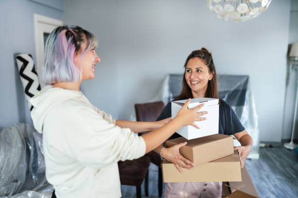 istock Young woman carrying a packing box into her new home 1284285234
