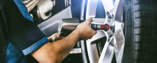 Auto mechanic working on car wheels in mechanics garage. Wheel Tyres Repair service. authentic close-up sho Auto mechanic working on car wheels in mechanics garage. Wheel Tyres Repair service. authentic close-up shot sho instrument stock pictures, royalty-free photos & images