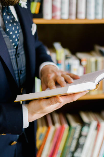 istock A man wearing elegant suit is reading a book in the library 1284285459