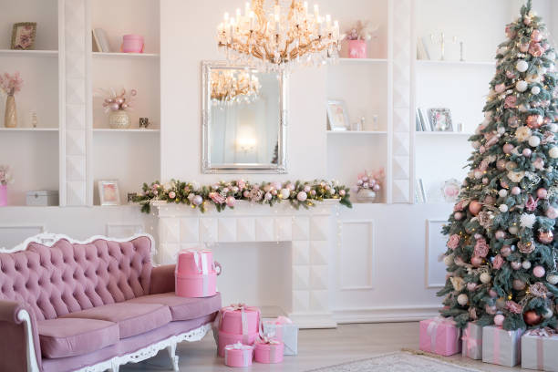 Interior of bright modern living room with fireplace and comfortable sofa decorated with Christmas tree and gifts Interior of bright modern living room with fireplace and comfortable sofa decorated with Christmas tree and gifts. pink christmas tree stock pictures, royalty-free photos & images