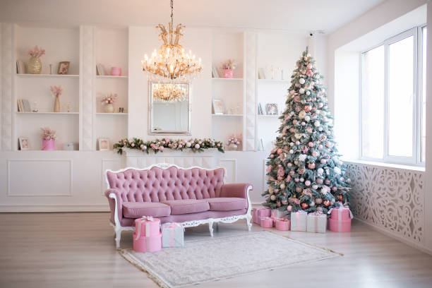 Interior of bright modern living room with fireplace and comfortable sofa decorated with Christmas tree and gifts Interior of bright modern living room with fireplace and comfortable sofa decorated with Christmas tree and gifts. pink christmas tree stock pictures, royalty-free photos & images
