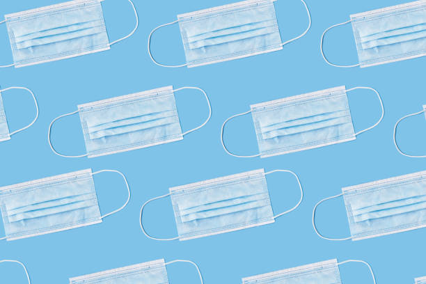 istock A medical mask pattern on a blue background. Covid-19 face mask pattern 1284287794