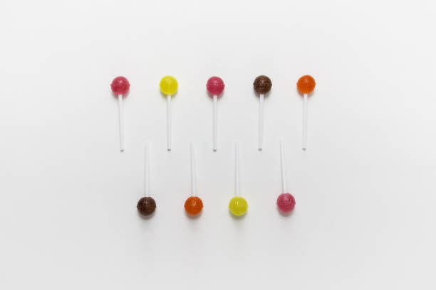 A glass jar filled with vibrant, colorful candy sticks sits in an Indian shop, set against a softly blurred background. The image captures sweetness, nostalgia, and a cheerful, inviting atmosphere.