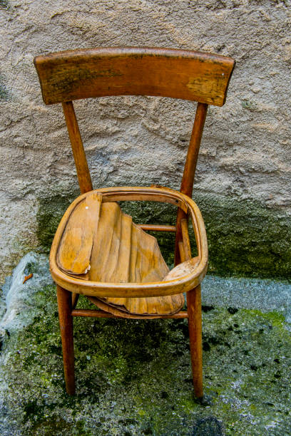 old wooden chair broken down and abandoned on the street corner