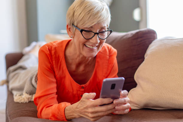 istock Senior woman relaxing at home using smart phone 1284294572