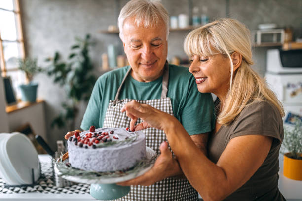 istock Couple holding fresh homemade cake in kitchen 1284294917