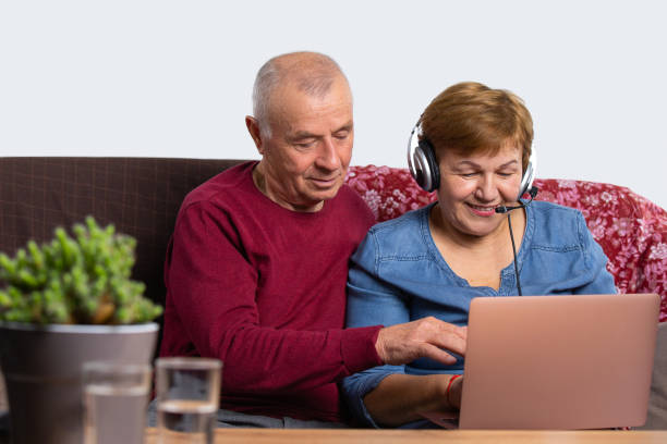 istock A woman works at home using a computer via video communication with a headset. The man became interested in her work. Senior online and pandemic concept. 1284297030
