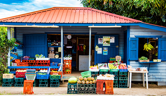 Blue and red colorful small mom& pop market in Belize offers fresh produce colorfully displayed in Placencia, Belize