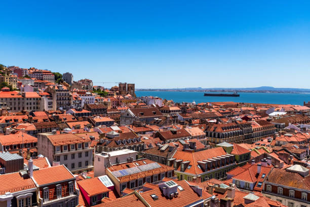 Lisbon rooftops and tanker in river Tagus. Lisbon, Portugal - May 13, 2019: Lisbon rooftops and tanker in river Tagus viewed from Santa Justa lift viewing platform. santa justa lift portugal stock pictures, royalty-free photos & images