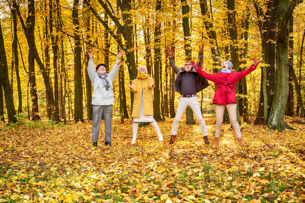 秋の公園で楽しんで幸せな先輩の友人のグループ。 - senior adult fun autumn senior couple ストックフォトと画像