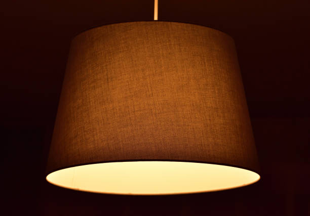 istock Modern chandelier with textile shade and bulb with warm white 1284308071