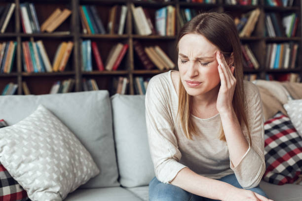 istock Woman alone sitting at library illness concept closed eyes having headache 1284308104