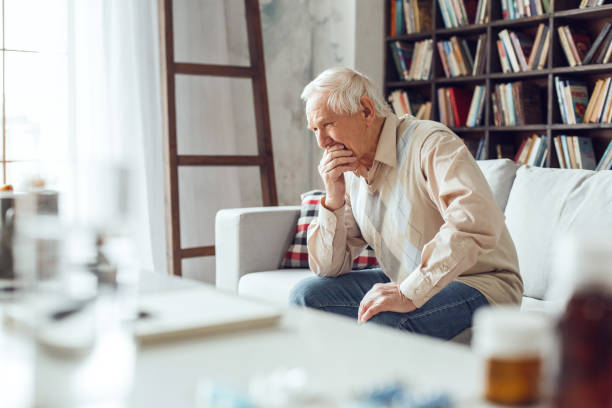 istock Senior man alone sitting at library table close-up crying emotional 1284308113