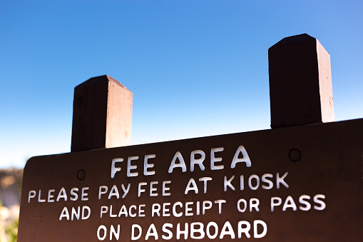 Wooden Sign in Wilderness Park:”PAY FEE AT KIOSK\