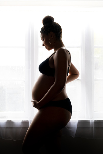 Silhouette of pregnant black woman.