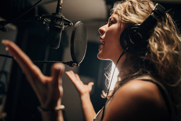 istock Female singer recording song in music studio 1284317546