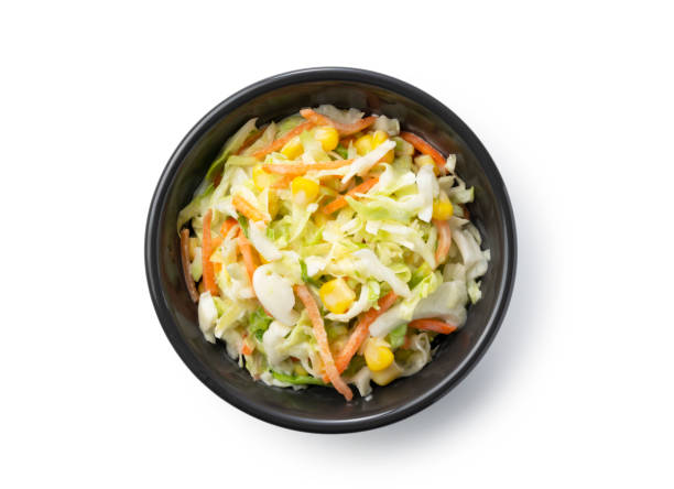 istock Coleslaw in a black bowl set against a white background. A view from above 1284317686