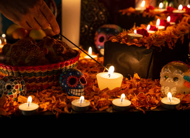 Hand holding incense stick over "ofrenda" for the Day of the Dead Hand holding incense stick over "ofrenda" for the Day of the Dead in Puebla, Pue., Mexico altar stock pictures, royalty-free photos & images