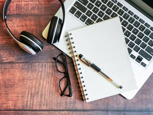 istock Open notebook and a laptop on wooden background. 1284327147
