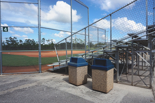 Recycling and Trash Containers by Bleachers in a Local Park