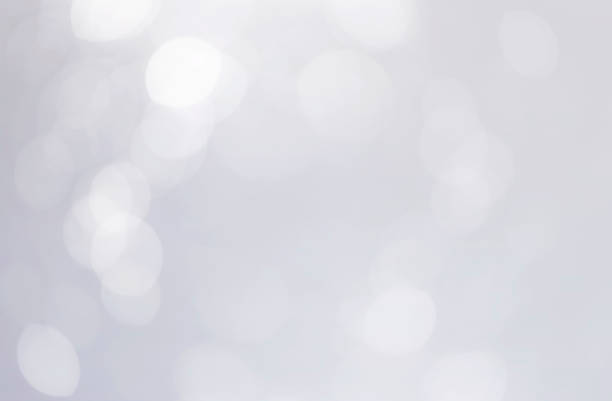 istock White bokeh lights abstract background. Defocused bokeh on soft gray background 1284328876