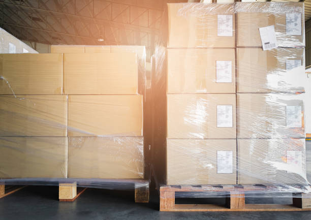 istock Cargo shipment boxes. Stack of cardboard boxes on pallet rack at the warehouse storage. Manufacturing and warehousing. 1284331563