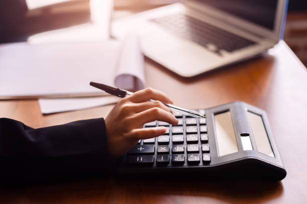 istock Business women  working with calculator and  business document on office table in office. finance accounting concept. 1284332449