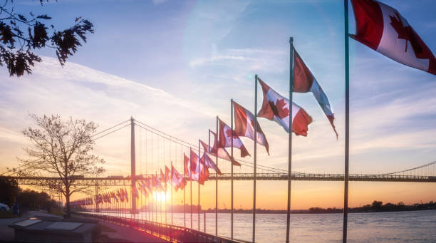 Ambassador Bridge at Dusk - View From Windsor, Ontario The Ambassador bridge links Detroit, Michigan with Windsor, Ontario.  It is one of the busiest trade routes in North America.  This photo was taken from Windsor, Ontario, Canada, facing North-West towards Detroit.  The body of water that the bridge traverses is the Detroit River. ontario flag stock pictures, royalty-free photos & images