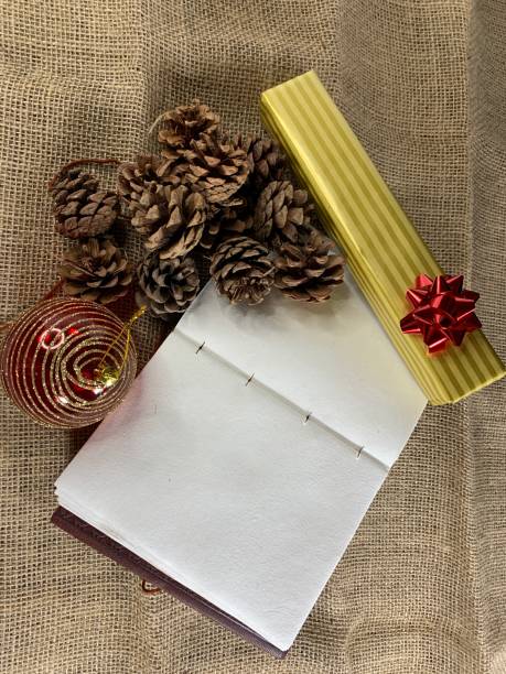istock Notebook with pine cones and gifts on linen 1284336086